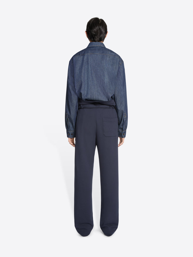 Person wearing a blue denim shirt and navy blue pants
