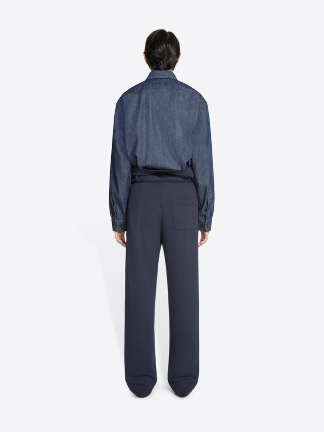 Person wearing a blue denim shirt and navy blue pants