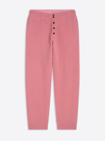 Pink ribbed pants with button details on a white background