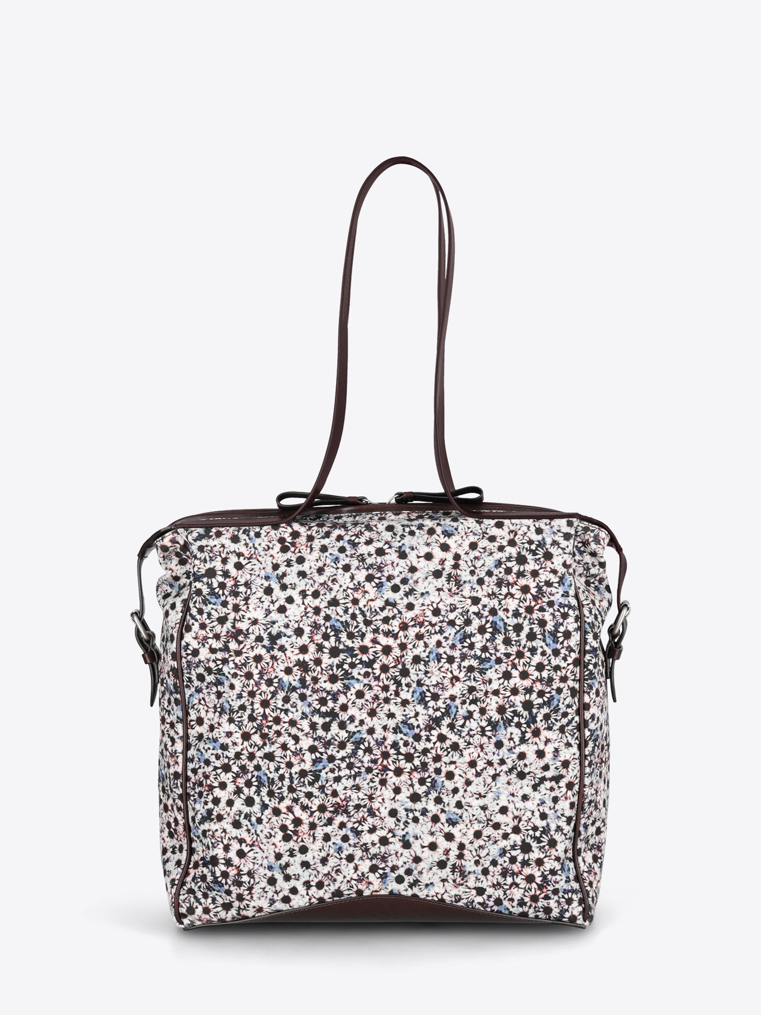 A structured tote bag with a dense multicolor floral print pattern on a white base, featuring dark brown leather trim and shoulder straps.