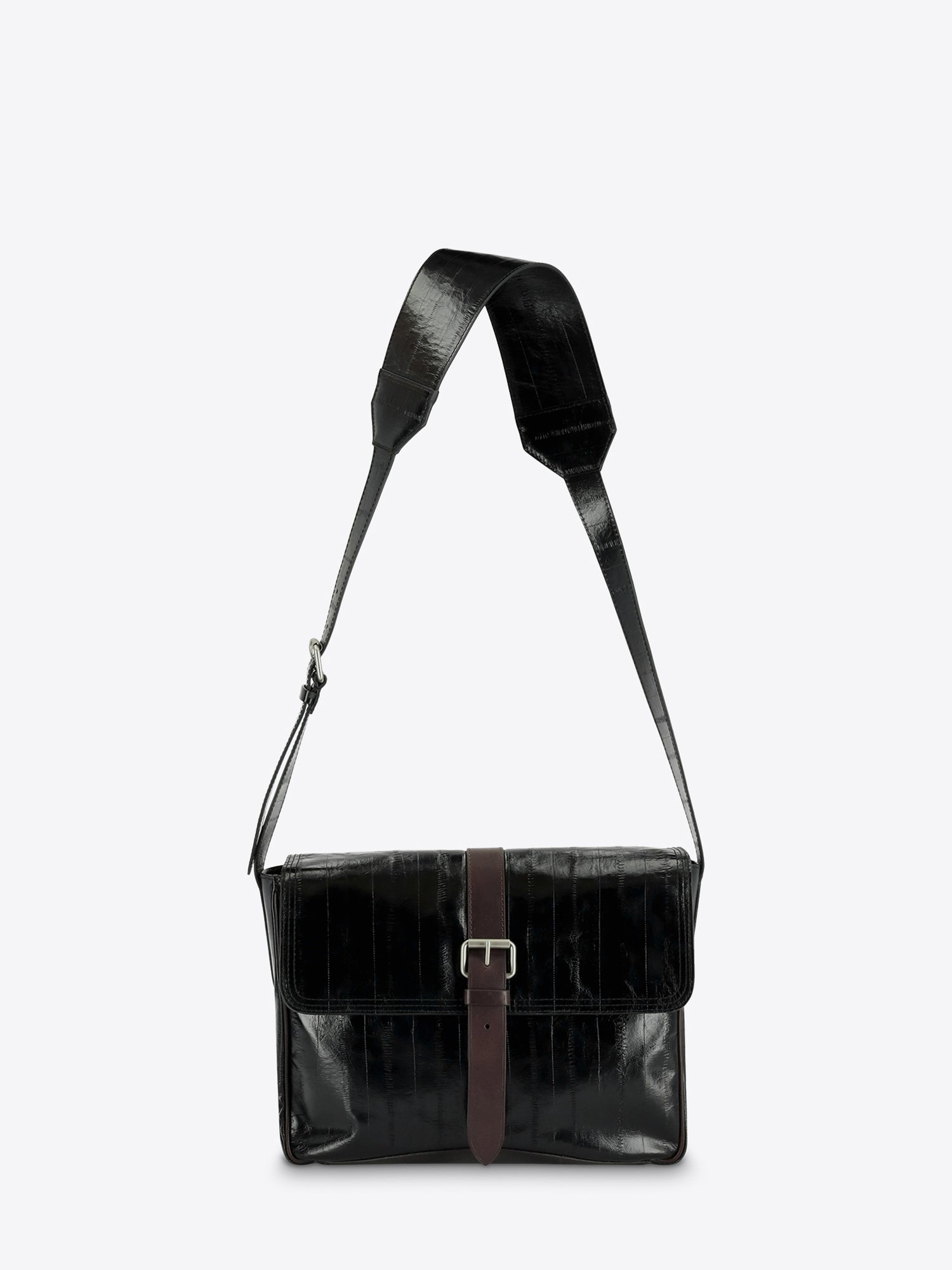 A black leather messenger bag with a brown leather strap detail and silver buckle, featuring a wide adjustable shoulder strap, shown against a light gray background.