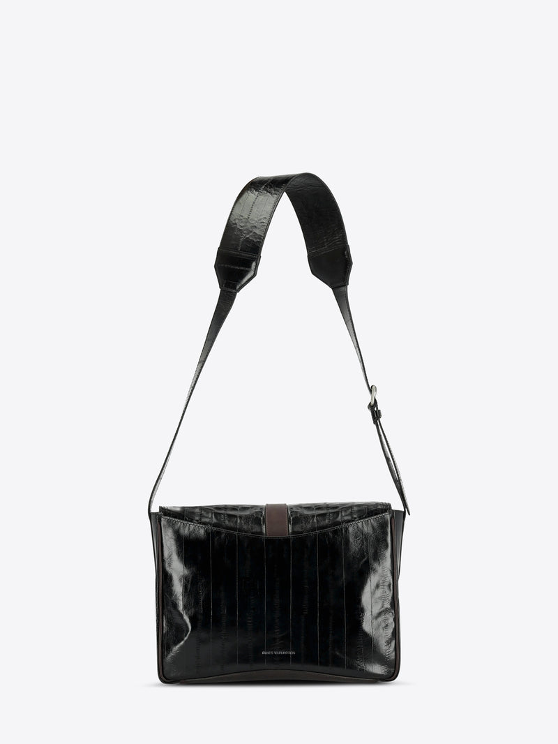 A black shoulder bag with a glossy, textured finish and a matching adjustable shoulder strap, shown against a light gray background.