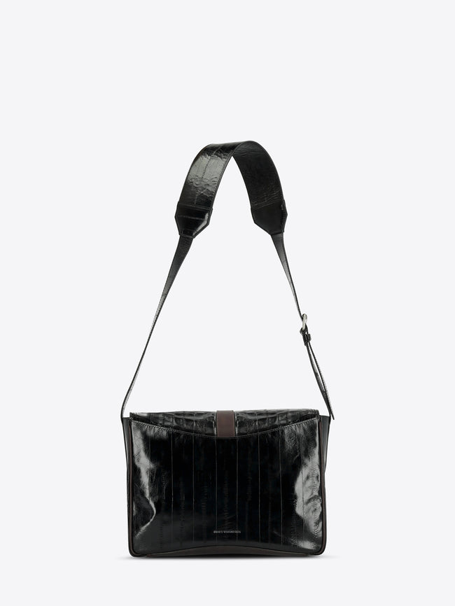 A black shoulder bag with a glossy, textured finish and a matching adjustable shoulder strap, shown against a light gray background.