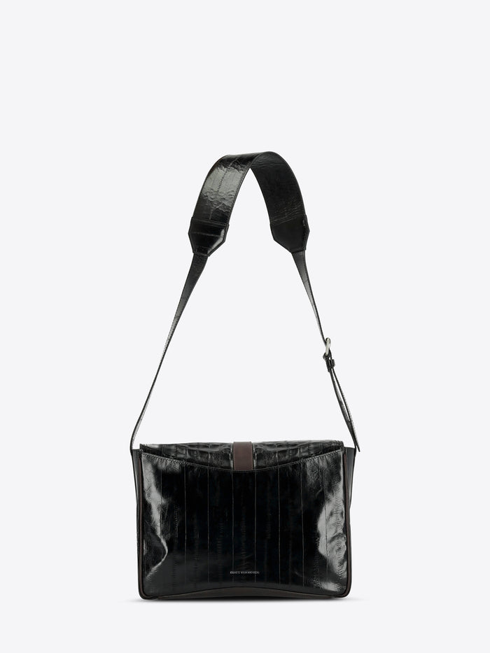 A black shoulder bag with a glossy, textured finish and a matching adjustable shoulder strap, shown against a light gray background.