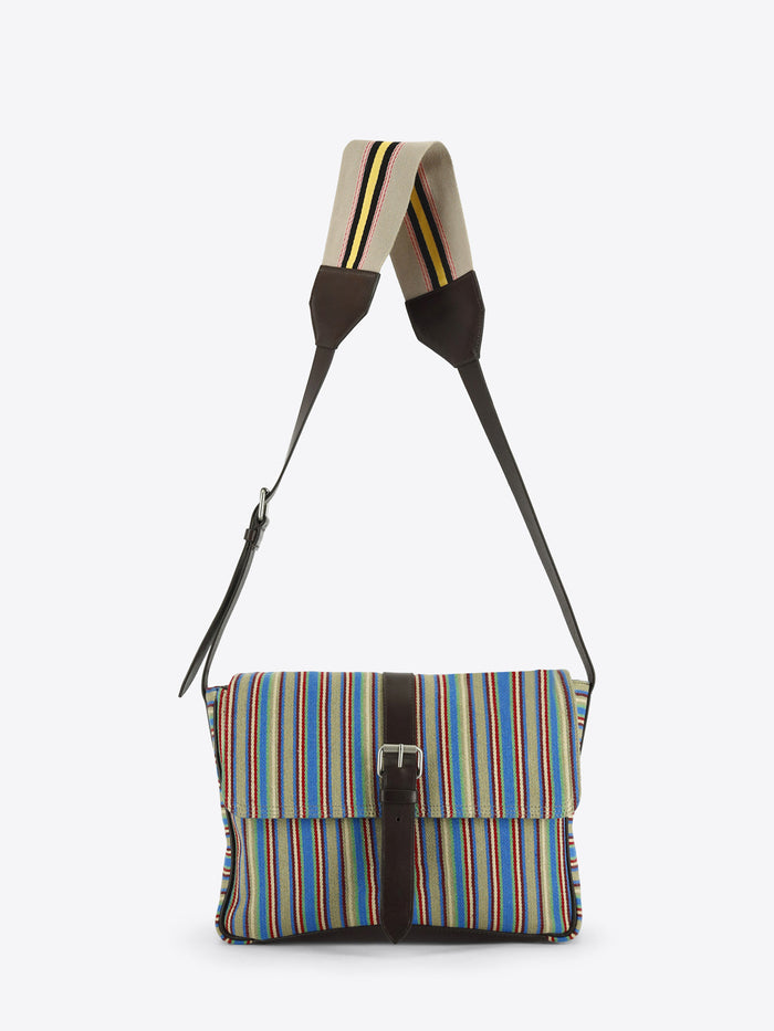 Multicolored striped shoulder bag with dark brown leather trim, a front buckle closure and an adjustable striped strap, shown against a light grey background.