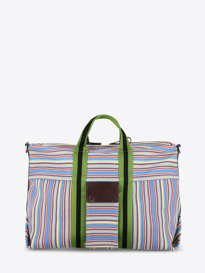 A striped bag with multicolor vertical stripes in blue, red, yellow, and white, featuring green handles and green side trim, set against a light gray background.