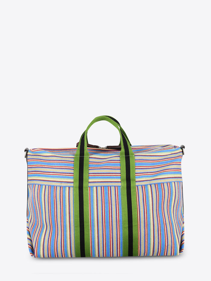 A striped bag with multicolor vertical stripes in blue, red, yellow, and white, featuring green handles and green side trim, set against a light gray background.