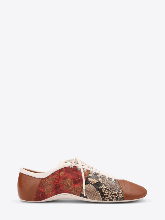 A low-top lace-up shoe featuring a brown leather toe and heel, a red and gold patterned side panel, and a snakeskin-patterned panel on the front, set against a light gray background.