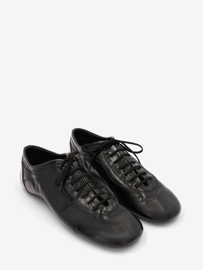 A pair of black leather low-top lace-up shoes with a glossy finish, displayed on a light gray background.