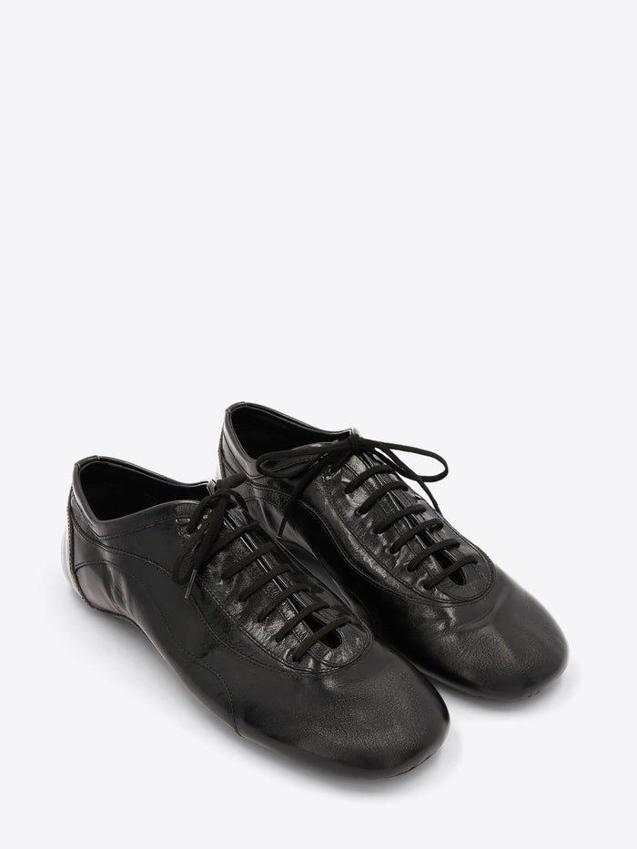 A pair of black leather low-top lace-up shoes with a glossy finish, displayed on a light gray background.