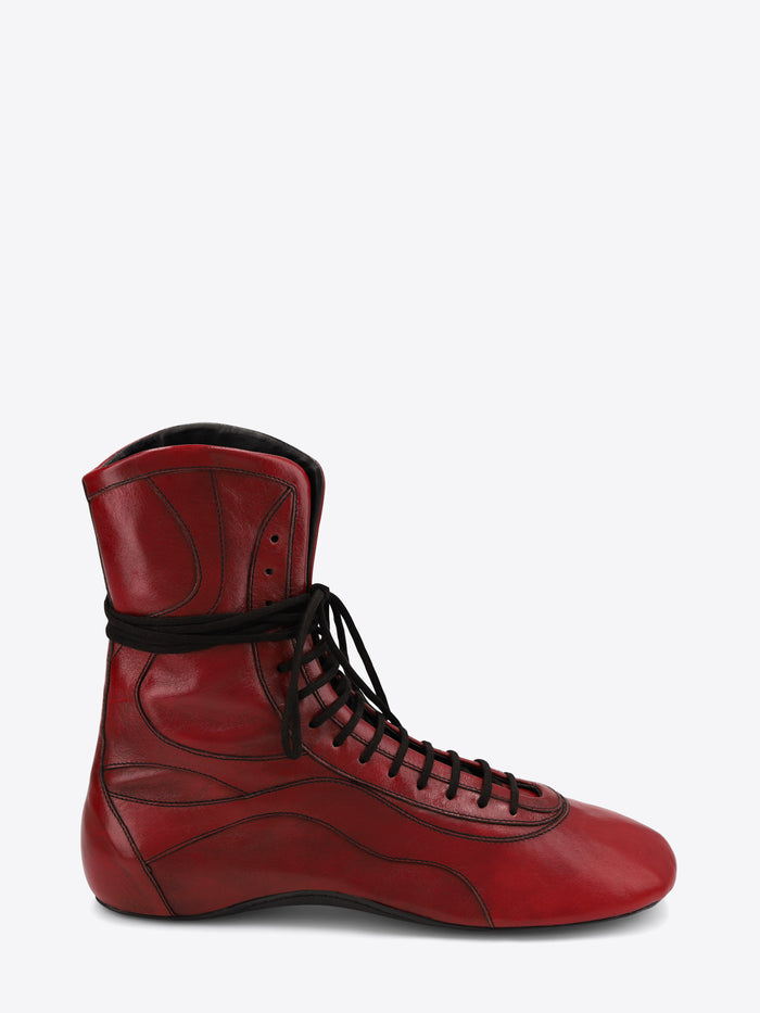 A single red leather lace-up shoe with black laces, shown on a light gray background.