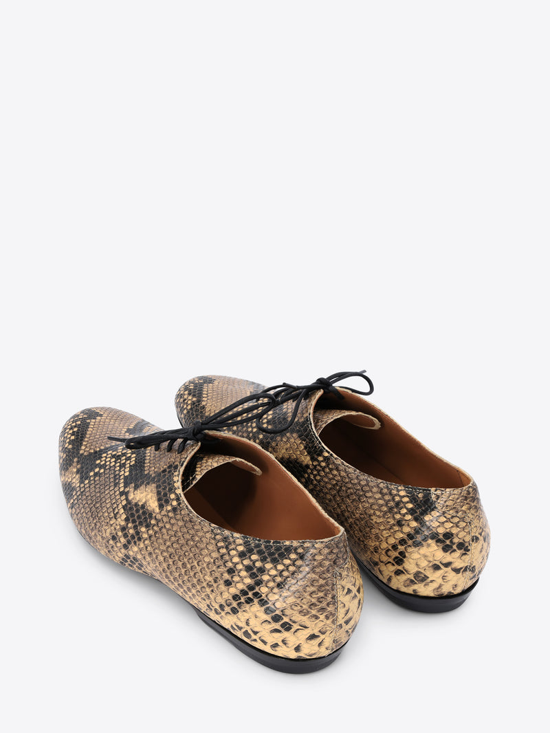 A pair of lace-up oxford shoes featuring a snakeskin pattern with black laces, shown on a light gray background.