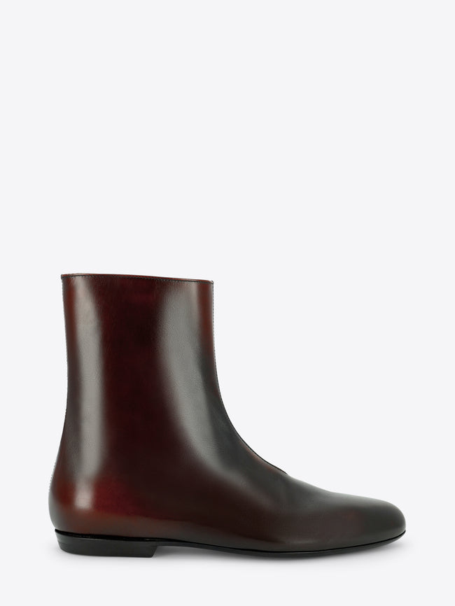 A dark brown leather ankle boot with a pointed toe and low black heel, shown in profile against a light gray background.