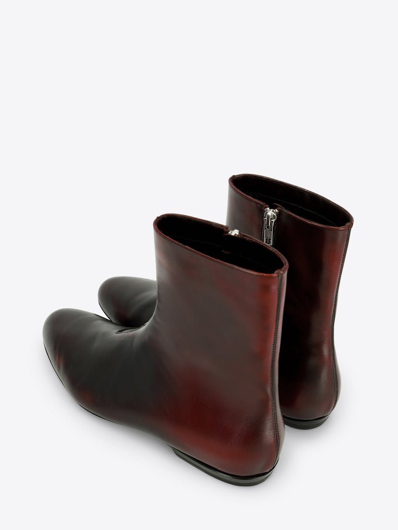 A pair of dark brown leather ankle boots with a side zipper shown on a light gray background.