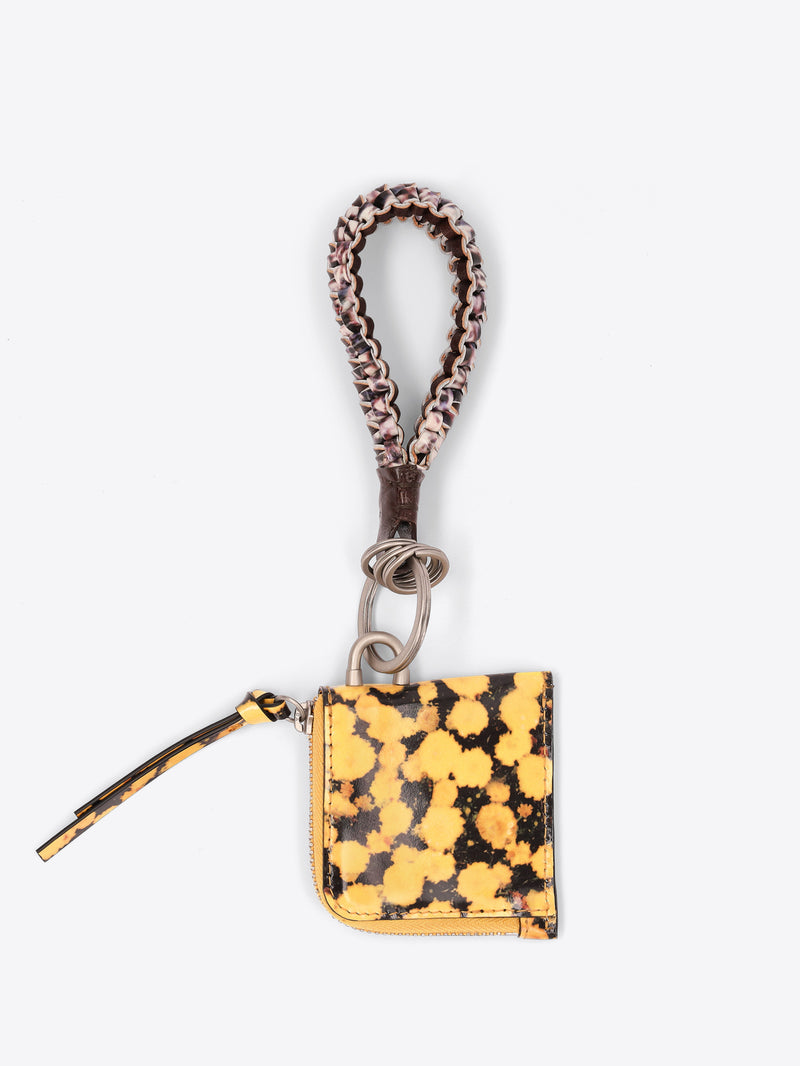 A small zippered pouch keychain with a yellow and black print body, a matching braided wristlet strap, and a silver metal key ring, shown on a light gray background.