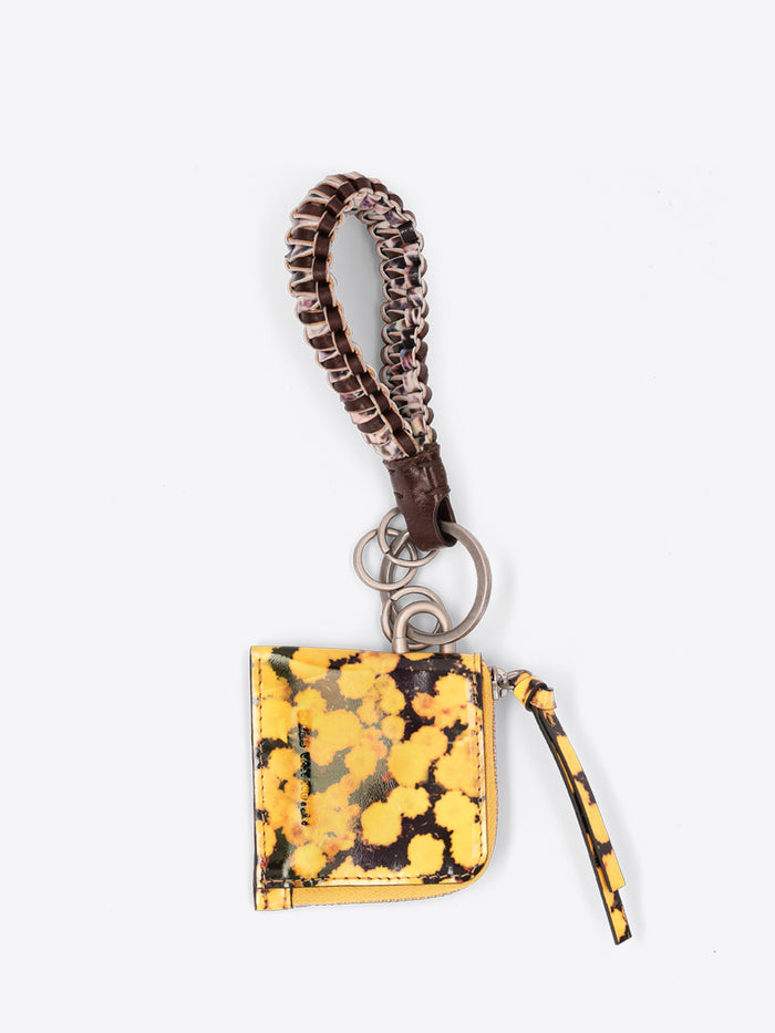 A small zippered pouch keychain with a yellow and black print body, a matching braided wristlet strap, and a silver metal key ring, shown on a light gray background.
