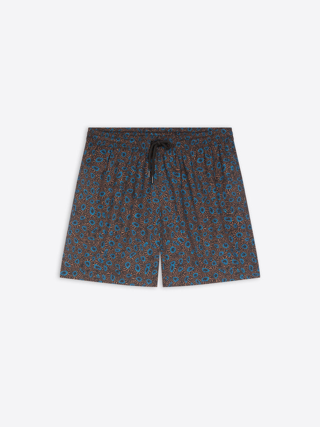 A pair of men's swim shorts featuring an all-over small-scale floral pattern in blue and brown on a dark base, with a matching dark drawstring at the elastic waistband, shown flat on a light gray background.