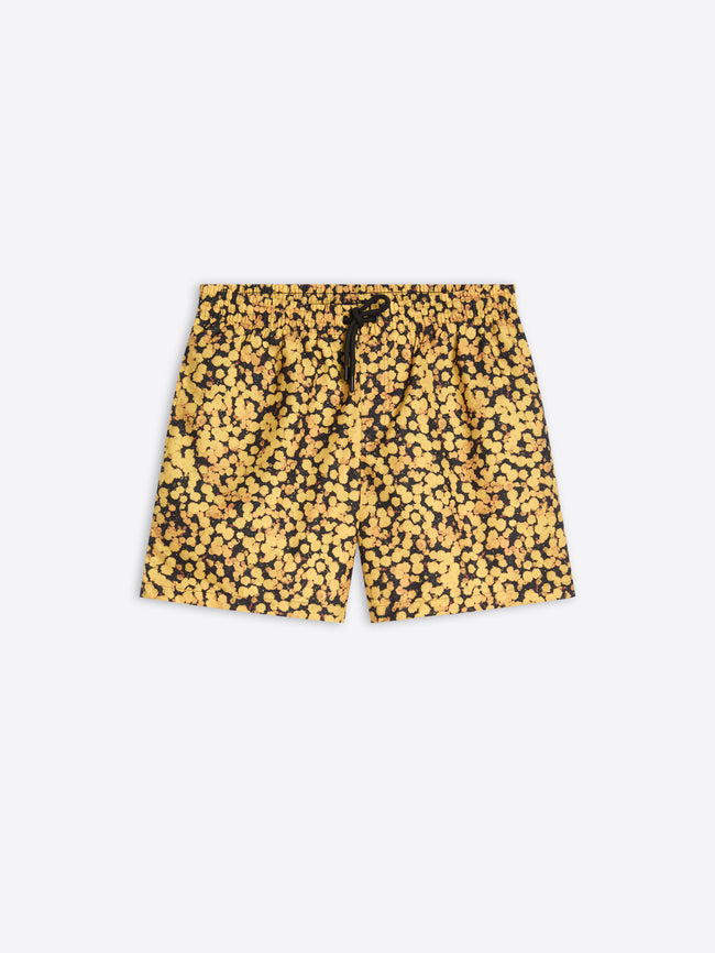 A pair of men's swim trunks featuring a dense yellow and black abstract floral, with a black drawstring at the elastic waistband, shown flat on a light gray background.