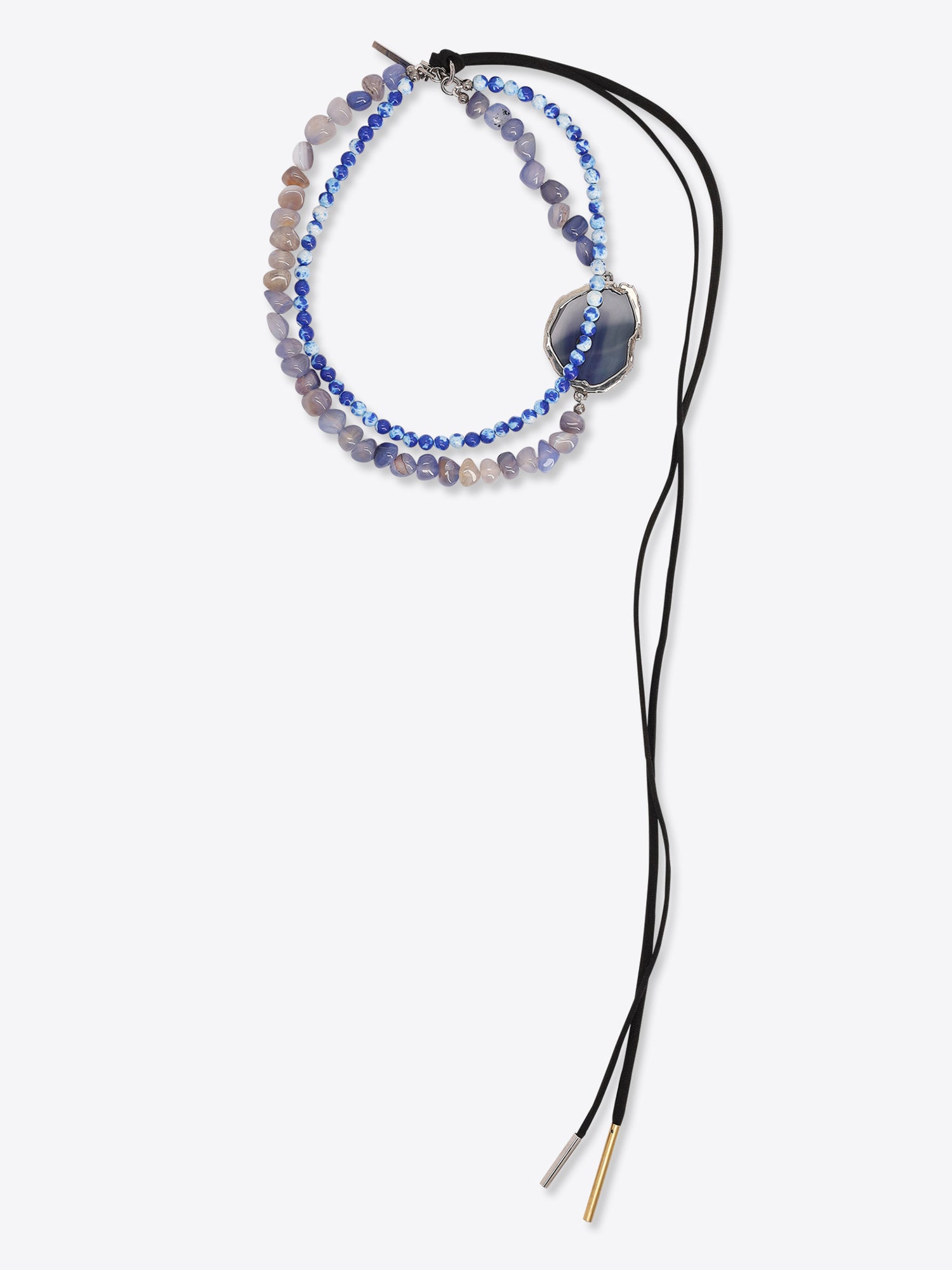 Two-strand necklace with lavender and blue beads, a blue stone pendant in a silver-toned setting, and long black tie cords on a light gray background.