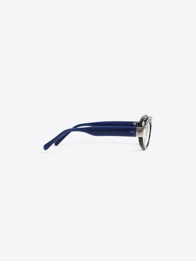 A round black-rimmed eyeglasses with dark blue acetate arms and a silver metal frame, shown from a side profile on a light gray background.