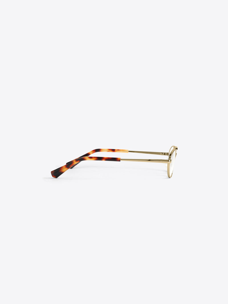 Pair of eyeglasses with gold frame and tortoiseshell arms on a light gray background