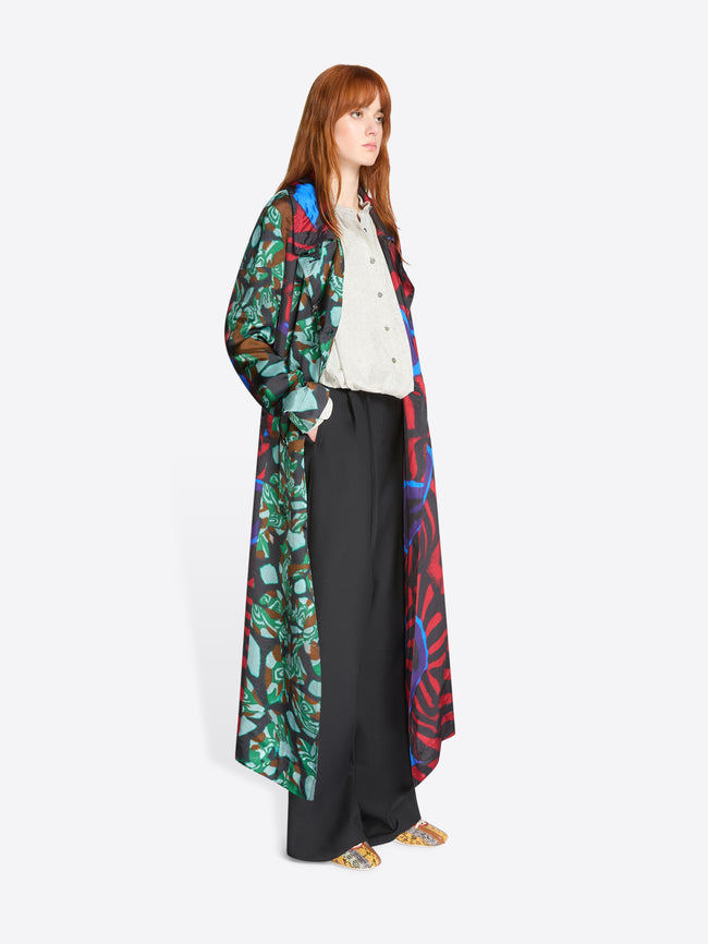 Woman wearing a colorful patterned coat on a white background