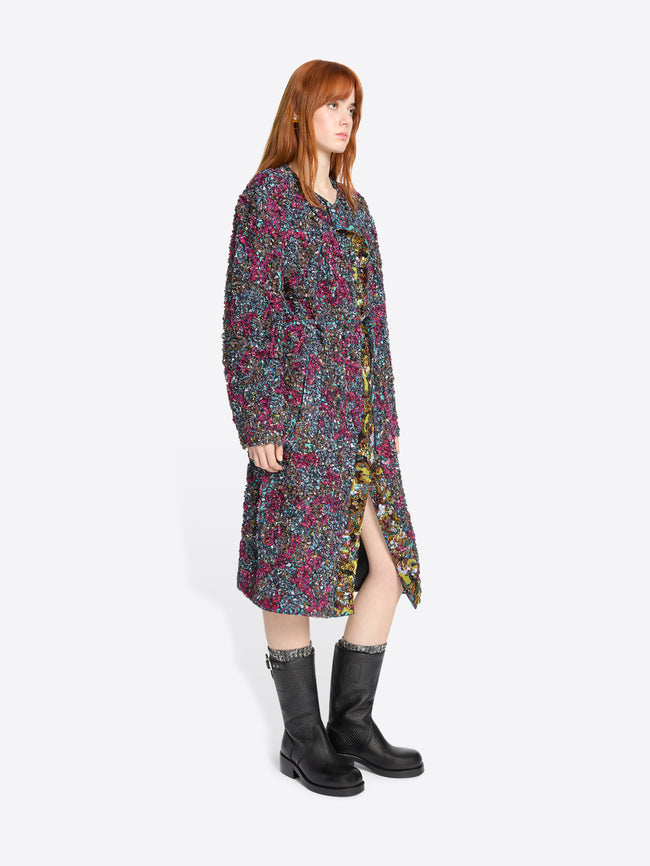 Woman wearing a colorful floral dress with on a white background
