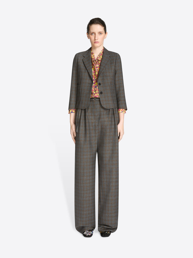 Woman wearing a gray suit with a patterned blouse on a white background