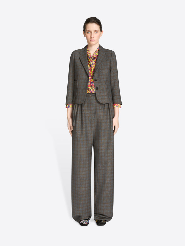 Woman wearing a gray suit with a patterned blouse on a white background