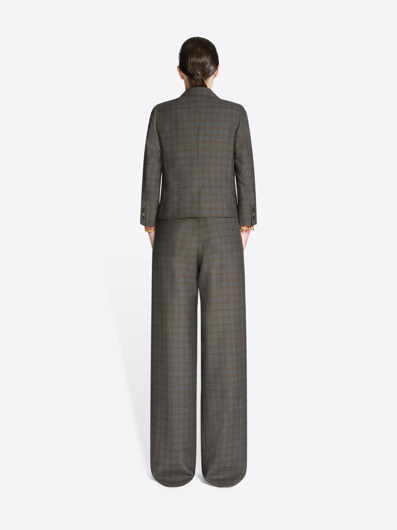 Back view of a person wearing a gray checkered suit on a white background