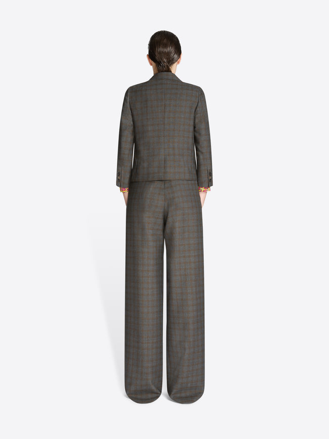 Back view of a person wearing a gray checkered suit on a white background