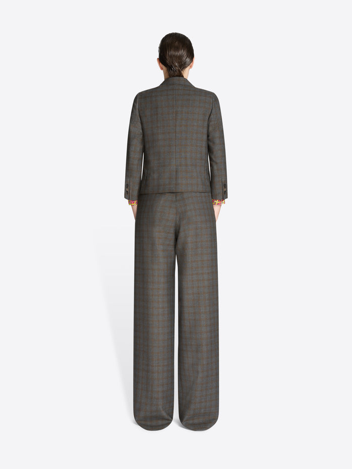 Back view of a person wearing a gray checkered suit on a white background
