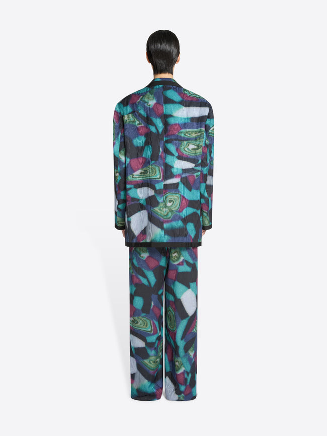 Back view of a person wearing a colorful patterned outfit on a white background