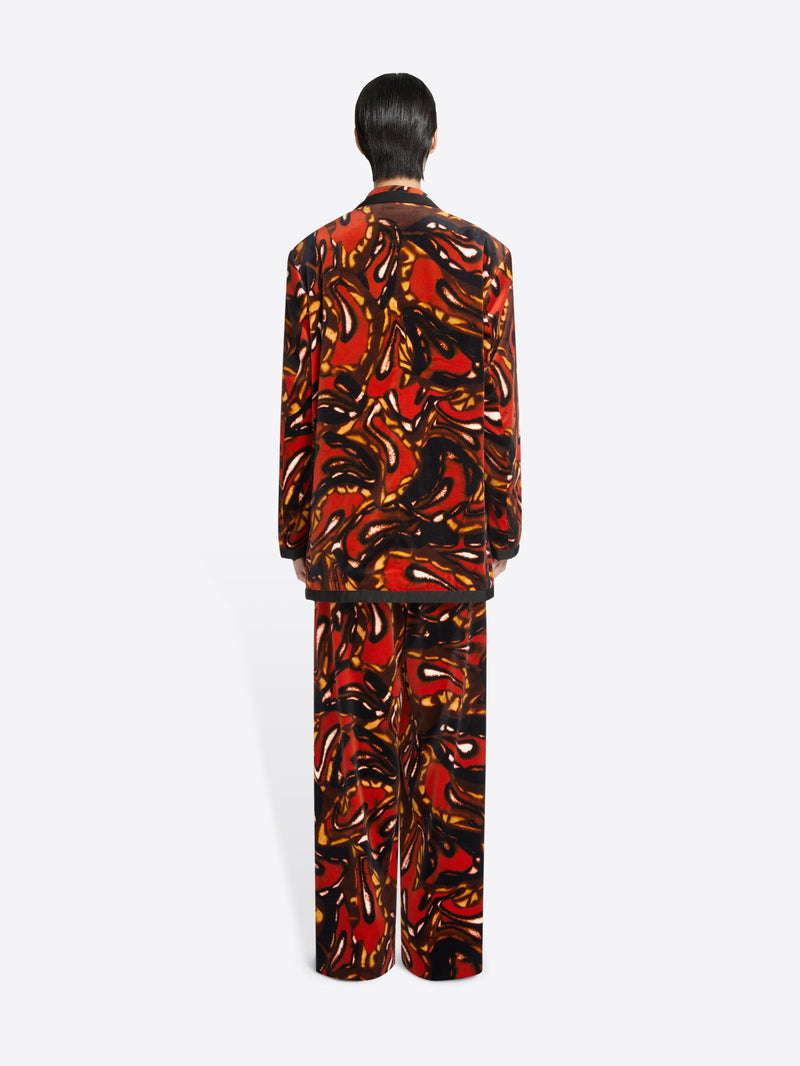 Back view of a person wearing a patterned outfit on a white background