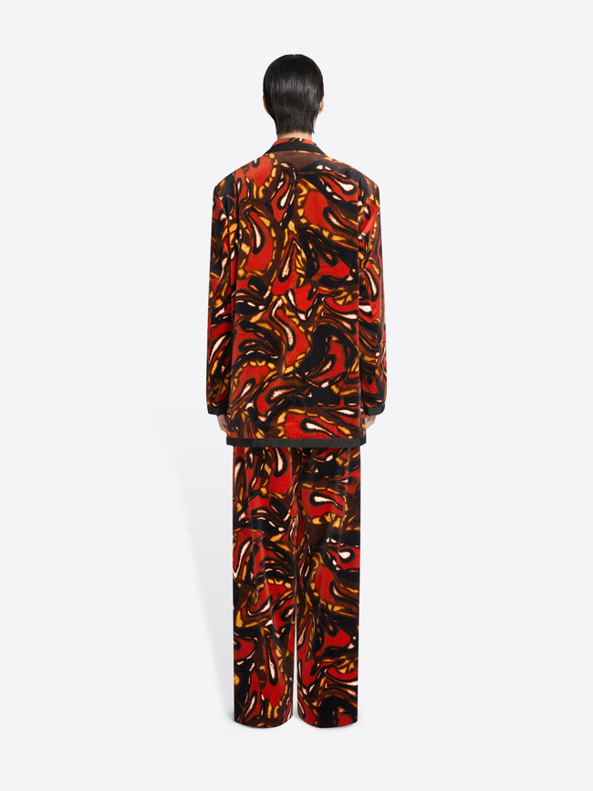 Back view of a person wearing a patterned outfit on a white background