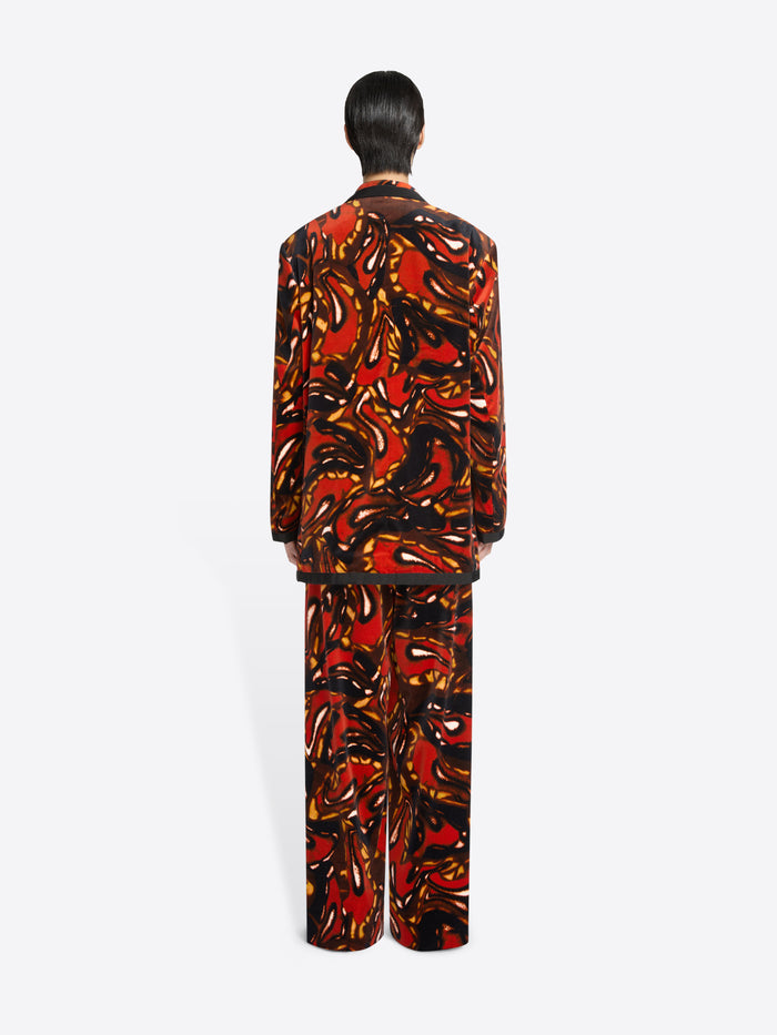 Back view of a person wearing a patterned outfit on a white background