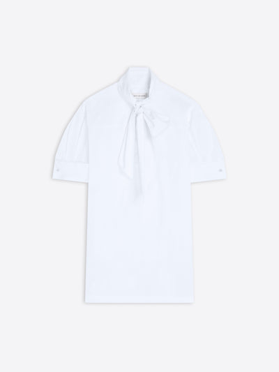 White blouse with a tie neckline on a light background
