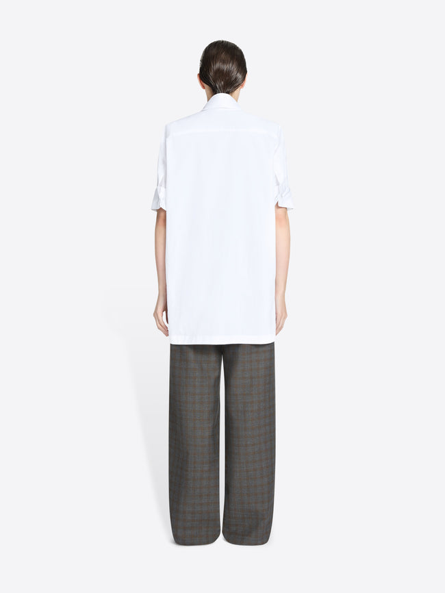 Back view of a person wearing a white shirt and gray checkered pants on a white background