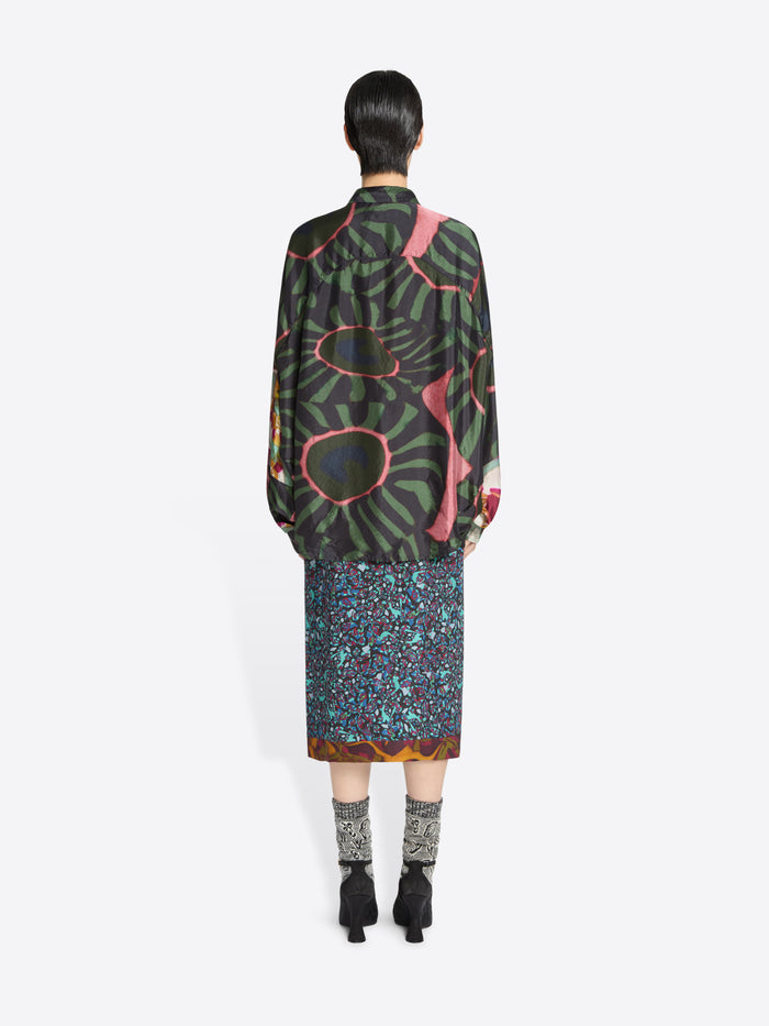 Back view of a person wearing a patterned outfit on a white background