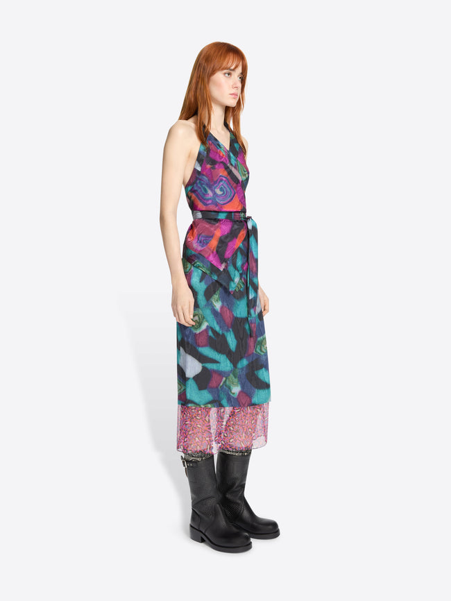 Woman wearing a colorful set with a pattern and black boots on a white background