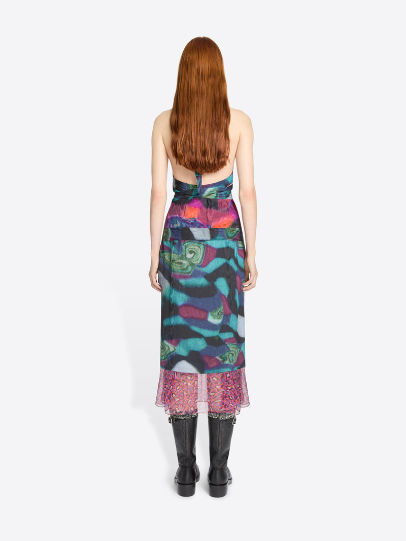 Model wearing a colorful set with a patterned hem on a white background