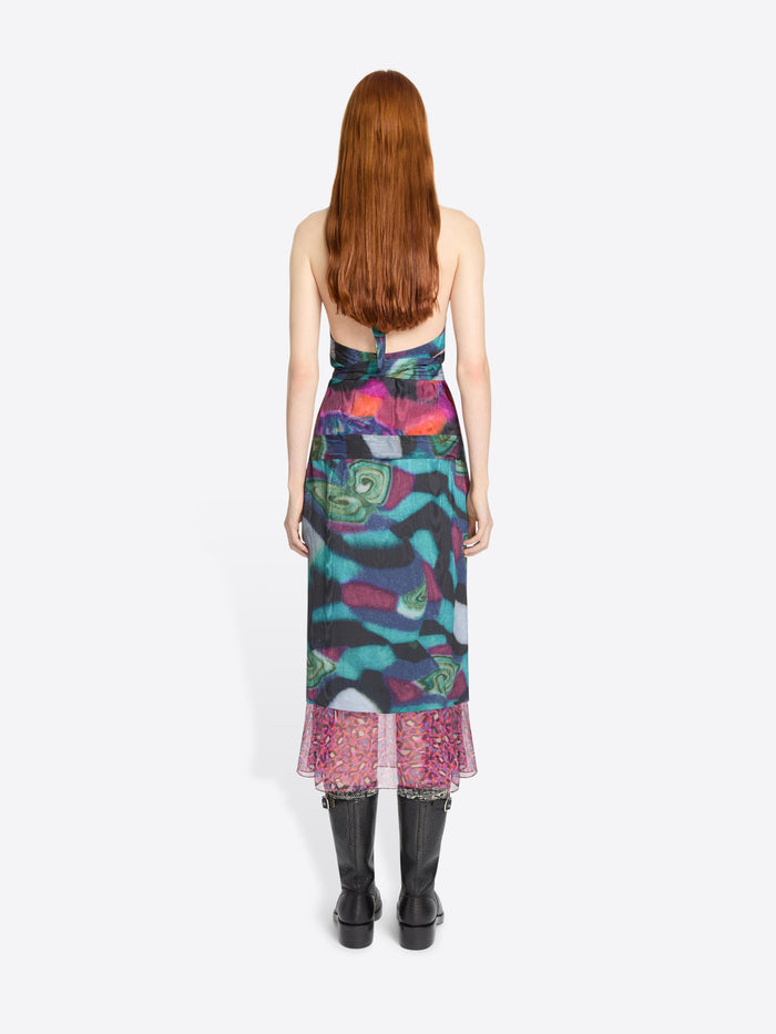 Model wearing a colorful set with a patterned hem on a white background