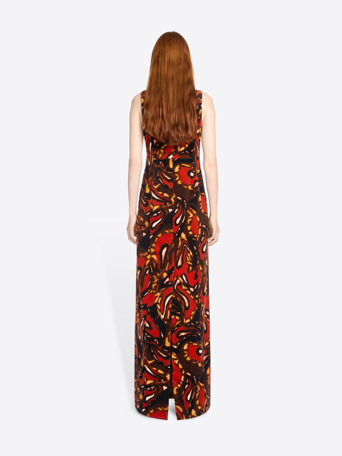 Back view of a woman wearing a sleeveless dress with a colorful abstract pattern on a white background