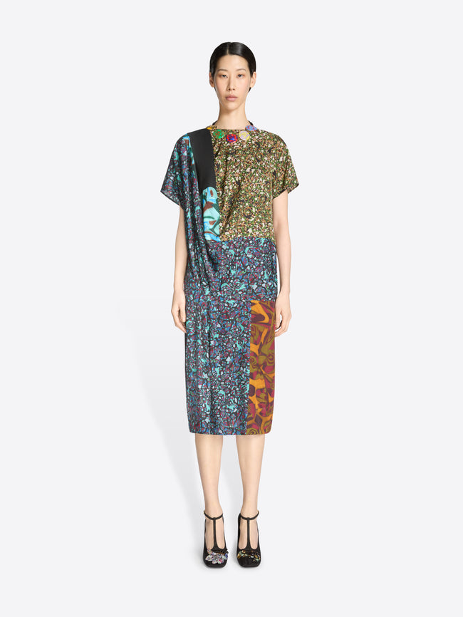 Model wearing a colorful dress with a patterned design on a white background