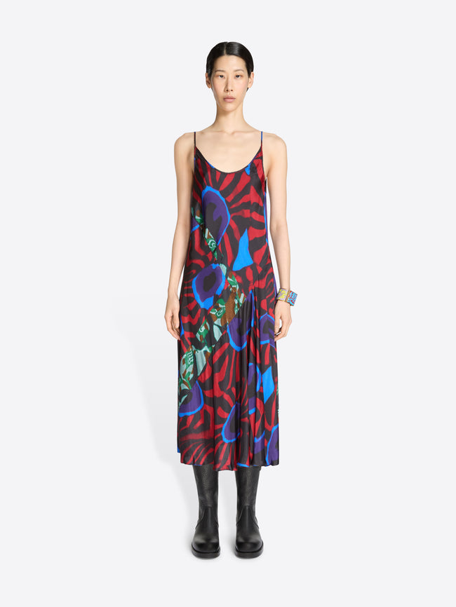 Model wearing a colorful dress with abstract patterns on a white background