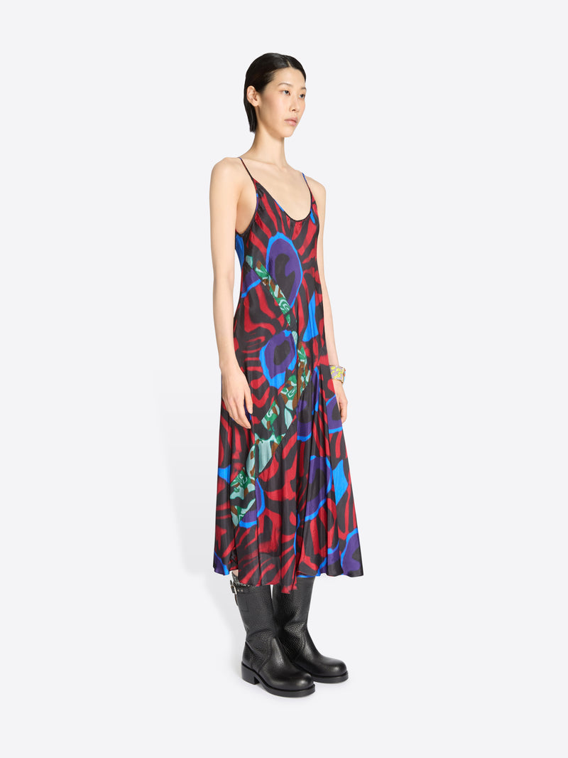 Woman wearing a colorful dress with abstract patterns on a white background