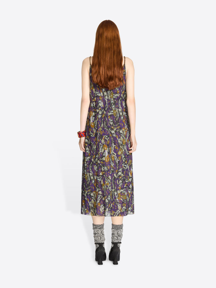 Back view of a woman wearing a sleeveless floral dress on a white background