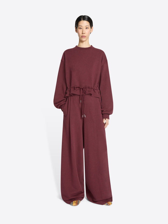 Person wearing a burgundy set on a white background