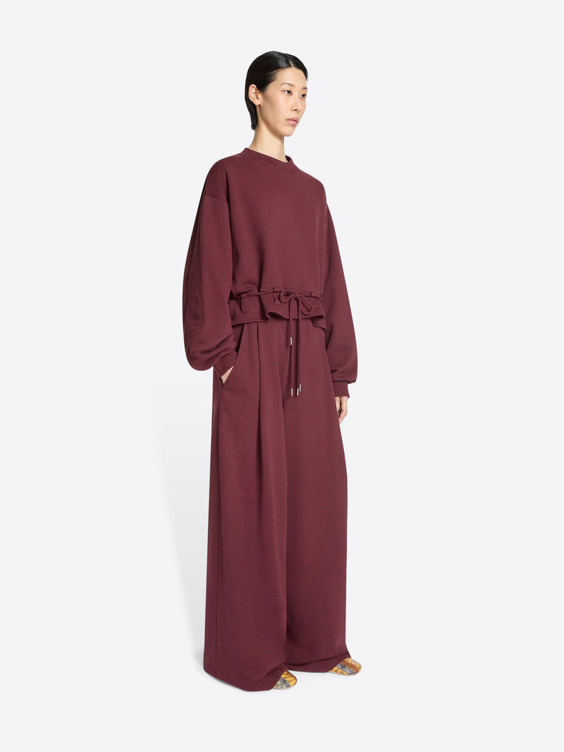 Burgundy pants, sweatshirt with long sleeves and a belt on a white background
