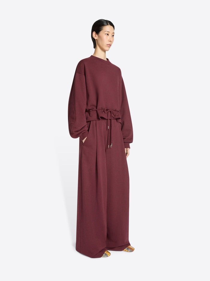Burgundy pants, sweatshirt with long sleeves and a belt on a white background